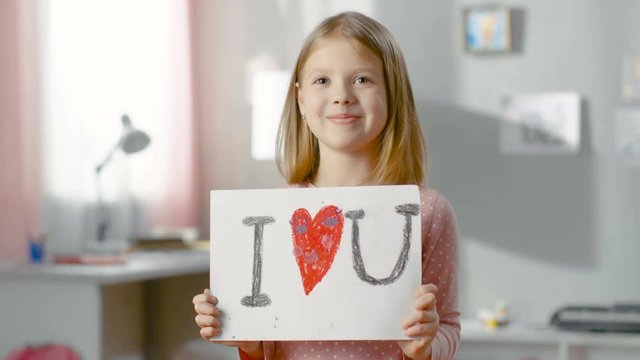 Cute Young Girl Shows Fun Drawing "I LOVE YOU" With Heart in the Middle.Shot on RED EPIC-W 8K Helium Cinema Camera.