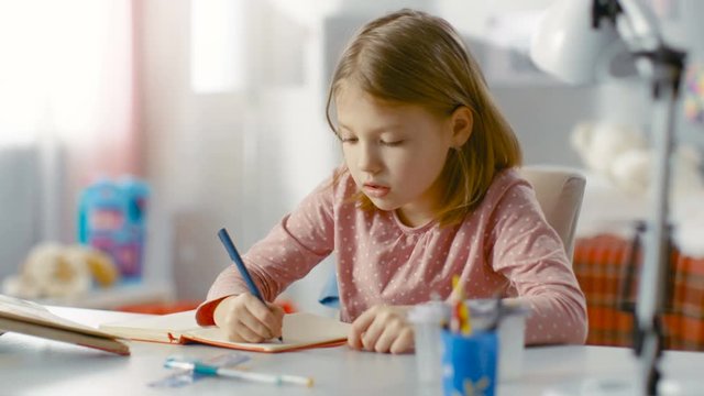 Cute Young Girl Does Homework in Her Bedroom. Shot on RED EPIC-W 8K Helium Cinema Camera.