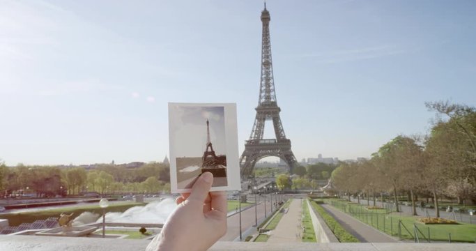 Hand holding instant photo in front of Eiffel Tower in Paris