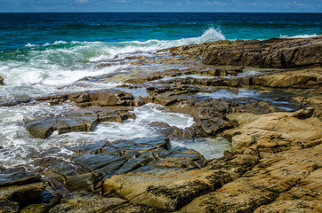 Fototapeta na wymiar Surf breaking over rocks