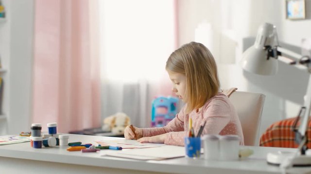 Sweet Little Girl Draws with Crayons in Her Light Room. Shot on RED EPIC-W 8K Helium Cinema Camera.