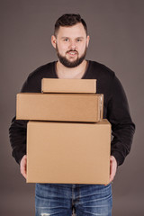 man holding pile of cardboard boxes in front