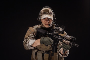 Naklejka premium Portrait soldier or private military contractor holding sniper rifle. war, army, weapon, technology and people concept. Image on a black background.