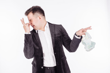 father holding dirty dirty diaper in one hand fingers over white background. Unpleasant smell stink.