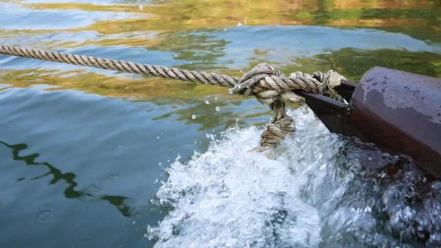 A knot of a rope from a travel raft that is drag by motor boat on the river Kwai, Thailand. 4K Movie