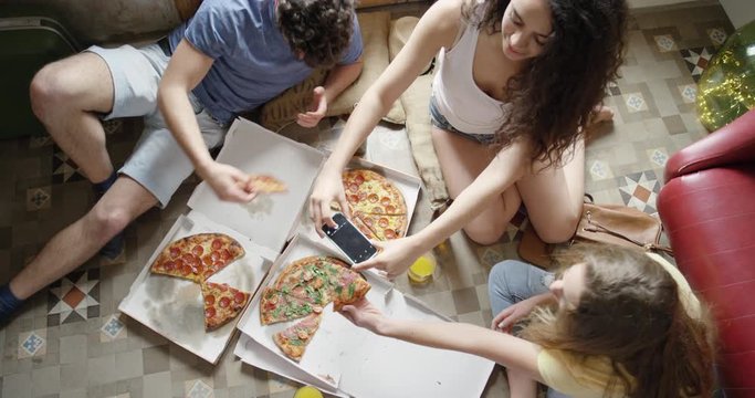 Mixed race group of friends eating pizza sharing food in spanish villa on vacation