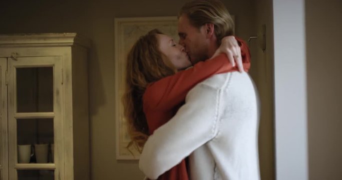 Attractive young couple making out kissing and sharing intimate moment hugging each other 