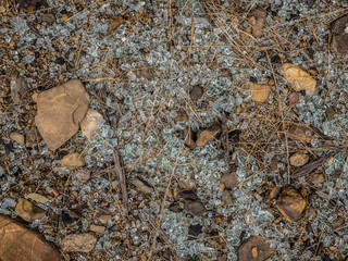 Obraz premium Smashed glass spread over the ground between rocks