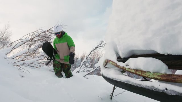Snowboarder Hiking Through Deep Snow and Trees