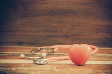 still life red heart and stethoscope on wood