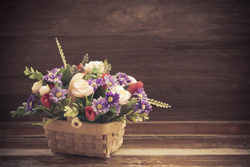 Fototapeta na wymiar still life flower in basket on old wood