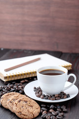 Coffee cup and coffee beans on wooden background