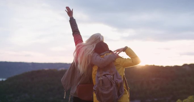 Happy girls dancing silly freestyle dance woman enjoying nature at sunset celebrating travel adventure best friends