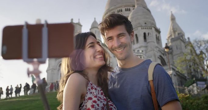 Tourist couple taking selfie photograph Sacre Coeur Paris with smartphone in city enjoying summer holiday European vacation travel adventure 