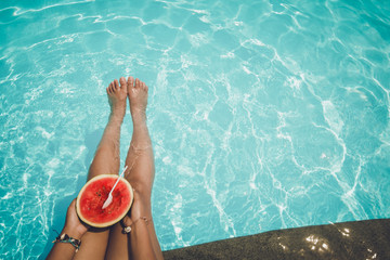 Relaxation and Leisure - Lifestyle in summer of Tanned girl holding watermelon (Tropical fruit) in the blue pool. Summer holiday idyllic.