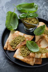 Stuffed crepes topped with basil pesto, close-up, selective focus