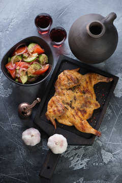 Tapaka chicken, georgian traditional cuisine. Flat-lay view on a grey stone background