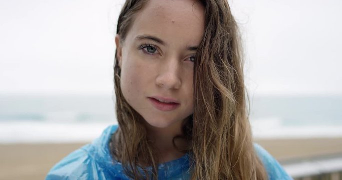Close up portrait of beautiful teenage girl smiling laughing wet hair blowing in wind in rainy weather slow motion