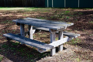 Empty old wooden bench and table in countryside playground, rural nature.