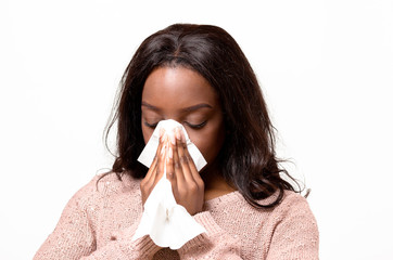 Unwell young woman blowing her nose