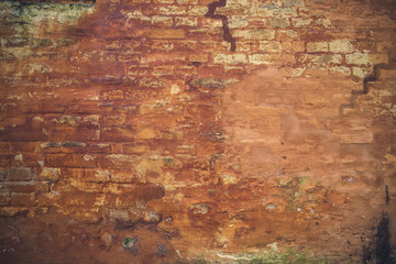 Grunge brick wall with peeling orange paint