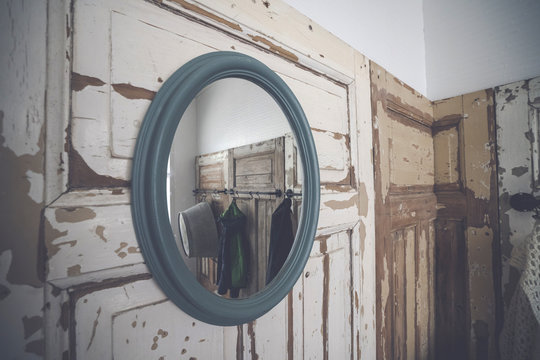 Round mirror hanging on a grunge wooden wall
