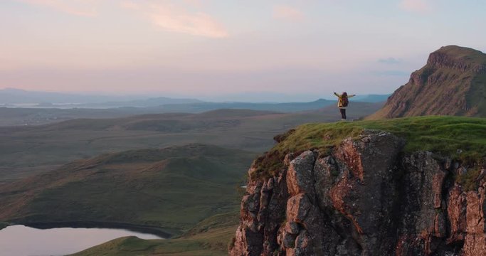 Woman with arms raised on top of mountain looking at Sunrise view Hiker Girl celebrating scenic landscape enjoying nature vacation travel adventure Quiraing Walk on the Isle of Skye in Scotland