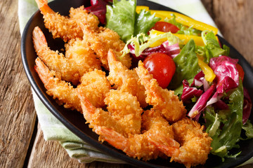 Japanese shrimps tempura and fresh vegetable salad close-up on a plate. horizontal