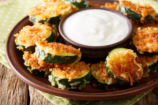 Spicy fried zucchini in breadcrumbs Panko and sour cream close-up. horizontal