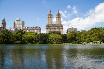 Fototapeta na wymiar Lake and trees at Central Park and buildings in Manhattan, New York