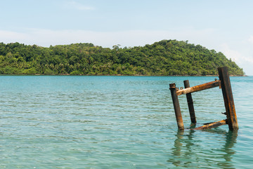 weathered steel docking part on a jetty against background of bright blue caribbean sea