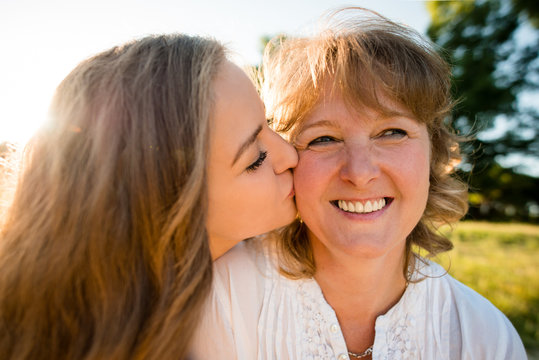 Happiness - teenage daughter kissing mother