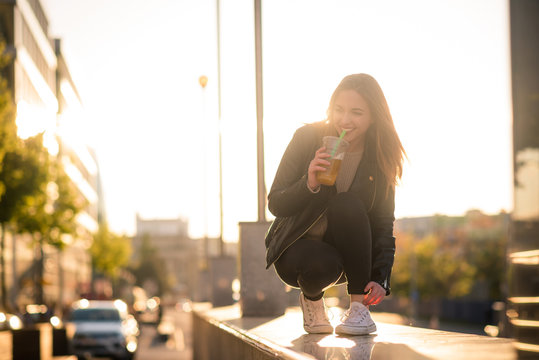 Woman drinking juice with straw in street