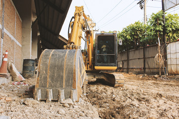 Fototapeta premium Excavator loader or backhoe at a construction site with soft-focus in the background. over light