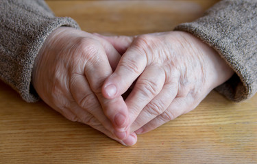 Female old hands on the table