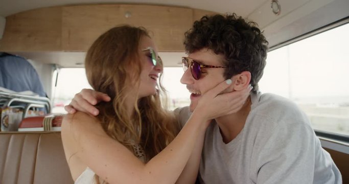 Portrait Beautiful teenage hipster friends posing for camera girl kissing on cheek smiling at festival in camper van on road trip adventure