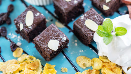 brownies and whip cream on a blue plate.
