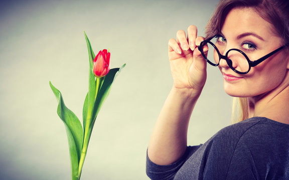 Seducive nerdy girl holding tulip.