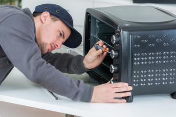 Obraz premium handyman fixing a portable oven