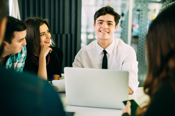 Startup diversity teamwork brainstorming meeting concept. People working planning start up. Group young people discussing in cafe. Focus on head of group.