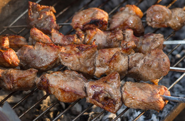 Pork meat cooking outdoor on smouldering carbons