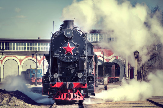 Fototapeta vintage steam train rides and smokes