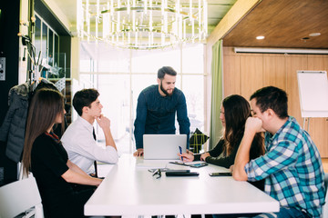 Young freelance team meeting at table discuss goals in modern office