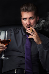 Entspannter Mann mit Zigarre und Wein