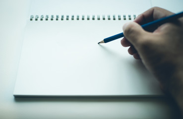 Hand writing on blank notebook with pencil, with copy space