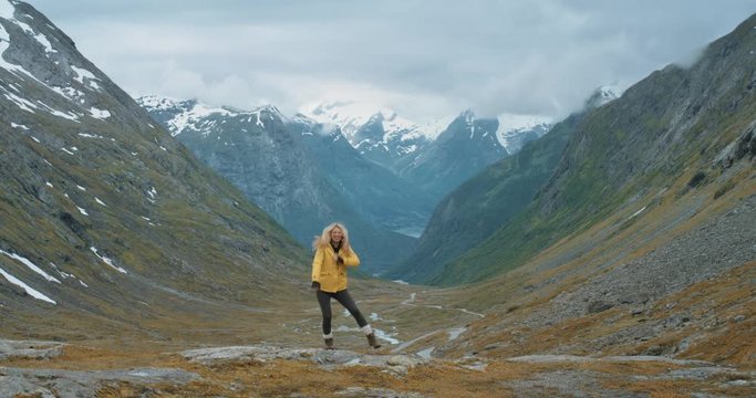Woman dancing silly freestyle dance outdoors on mountain Crazy dancer girl having fun Independent traveller enjoying nature celebrating vacation travel adventure Norway