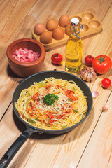 Tasty spaghetti with tomato sauce and meat in pan on wooden table.
