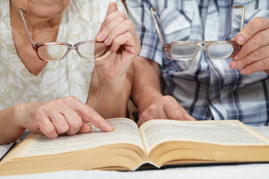 An elderly couple reading a book