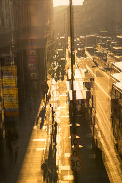Multiple exposure image of the York road at sunset. Buses, cars and walking people against of sun. 