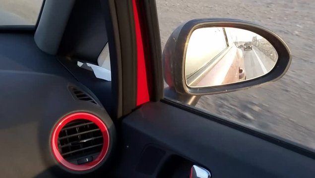 Highway travel seen from side mirror